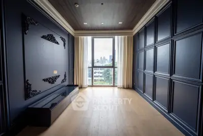 Luxurious empty room with elegant paneling and large window offering city views.