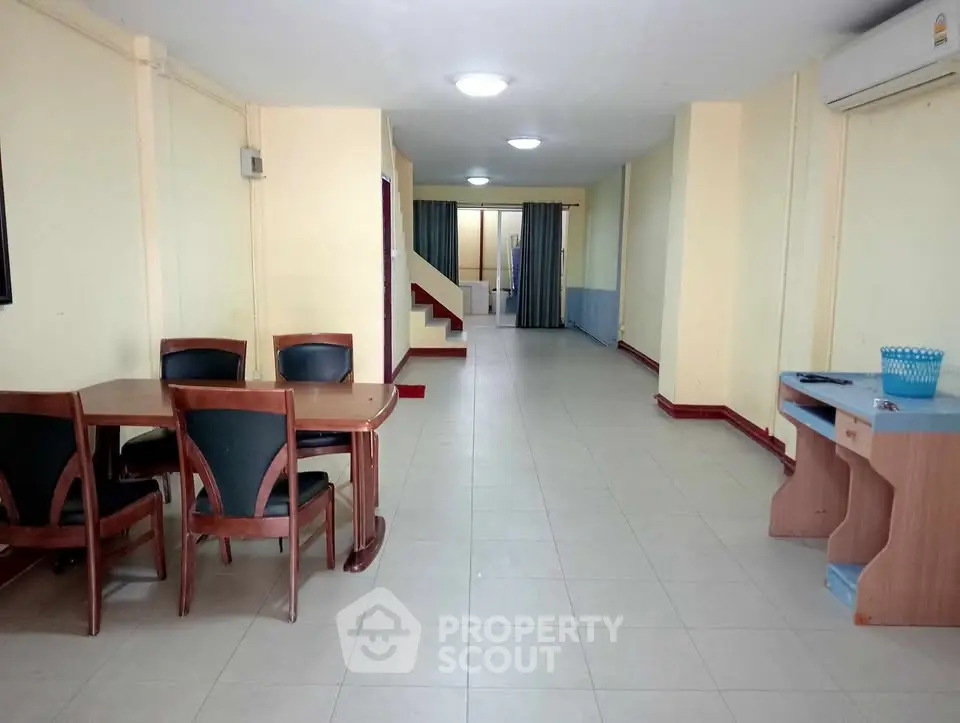 Spacious open-plan living area with dining table and desk, ideal for versatile use.