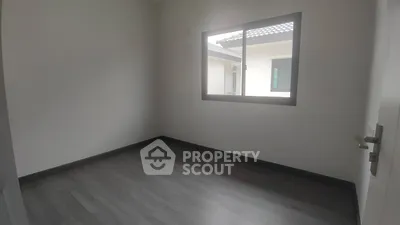 Spacious empty room with large window and modern flooring