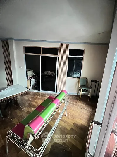 Spacious living room with wooden flooring and modern furniture in a stylish apartment.