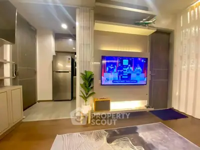 Modern living room with stylish decor and wall-mounted TV, featuring sleek flooring and contemporary design.