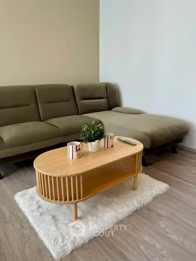 Stylish living room with modern sofa and chic coffee table on plush rug.