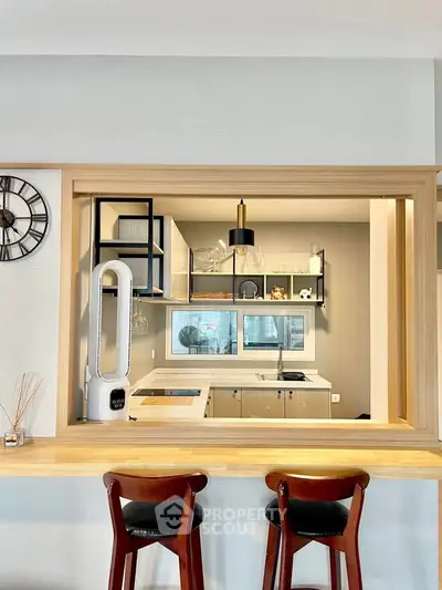 Modern kitchen with open layout and stylish bar seating, featuring sleek appliances and contemporary decor.