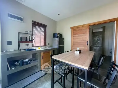 Modern kitchen with sleek design and open layout, featuring a dining area and stainless steel appliances.