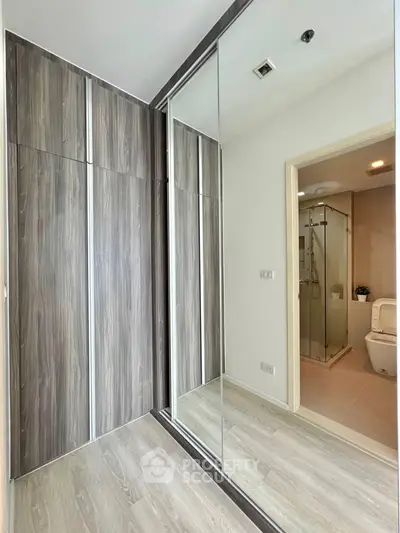 Modern bathroom with glass shower and mirrored closet doors