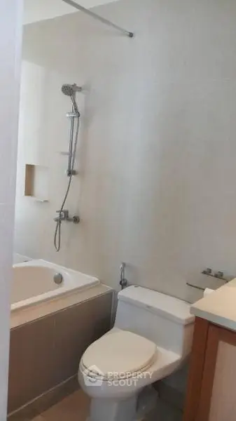 Modern bathroom with bathtub and shower in a sleek real estate property.