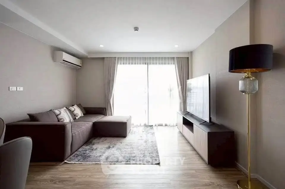 Modern living room with sleek furniture and large window for natural light.