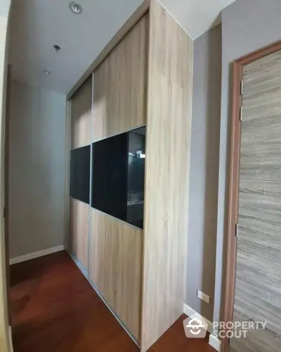 Modern hallway with sleek wooden wardrobe and elegant door design