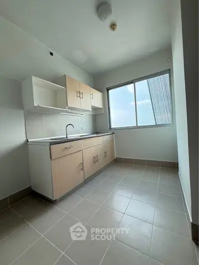 Spacious kitchen with ample natural light and modern cabinetry.
