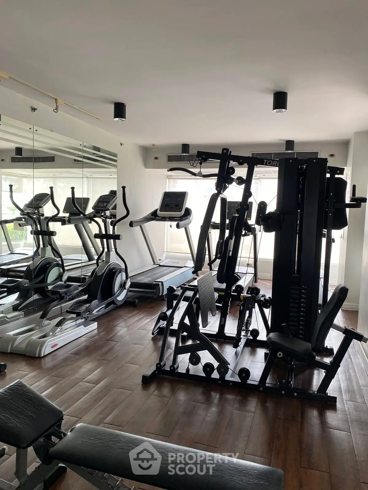 Modern gym with state-of-the-art fitness equipment and mirrored walls.