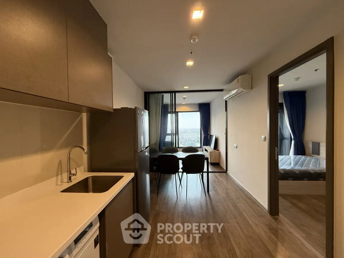 Modern apartment interior with open kitchen and living room, featuring a great view.
