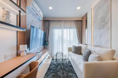 Modern living room with stylish decor, large TV, and cozy seating area, perfect for relaxation and entertainment.