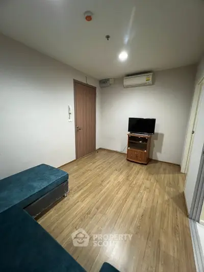 Cozy living room with wooden flooring and modern furniture in a compact apartment.