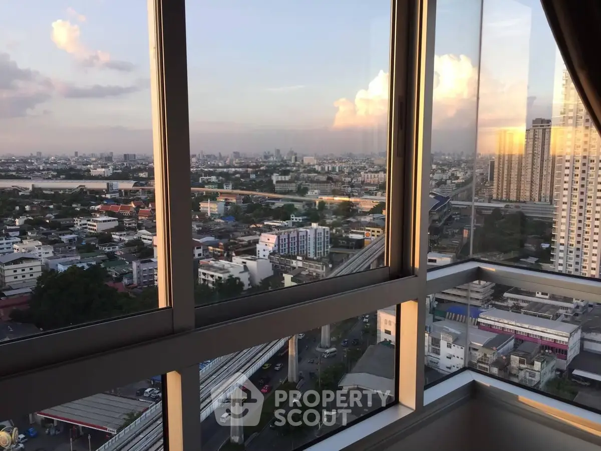 Stunning cityscape view from high-rise apartment window at sunset.