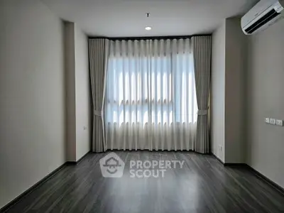 Spacious empty room with elegant curtains and wooden flooring, ideal for customization.