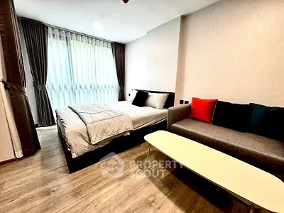 Modern bedroom with cozy bed and stylish sofa in a well-lit space.