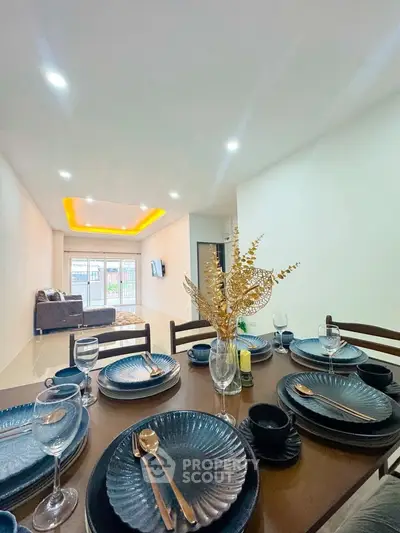 Modern dining area with elegant table setting and view of spacious living room
