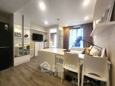 Modern studio apartment with sleek furnishings and ample natural light, featuring a cozy living area and stylish decor.
