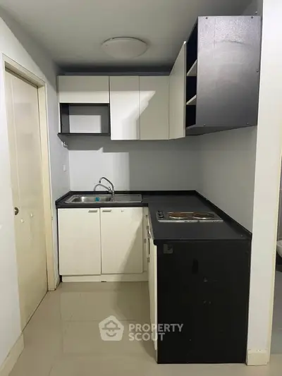 Compact modern kitchen with sleek cabinetry and integrated sink, ideal for urban living.