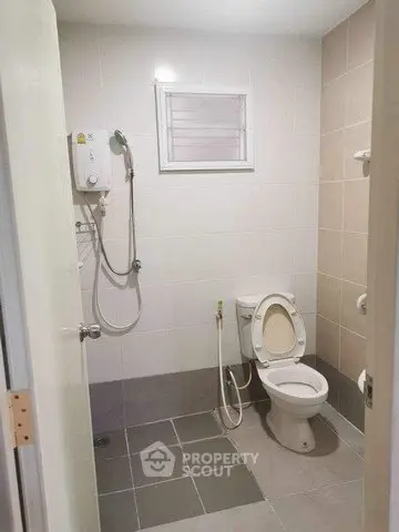 Modern bathroom with shower and toilet in a minimalist design.