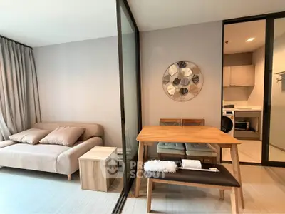 Modern living room with cozy sofa, dining table, and open kitchen in stylish apartment.