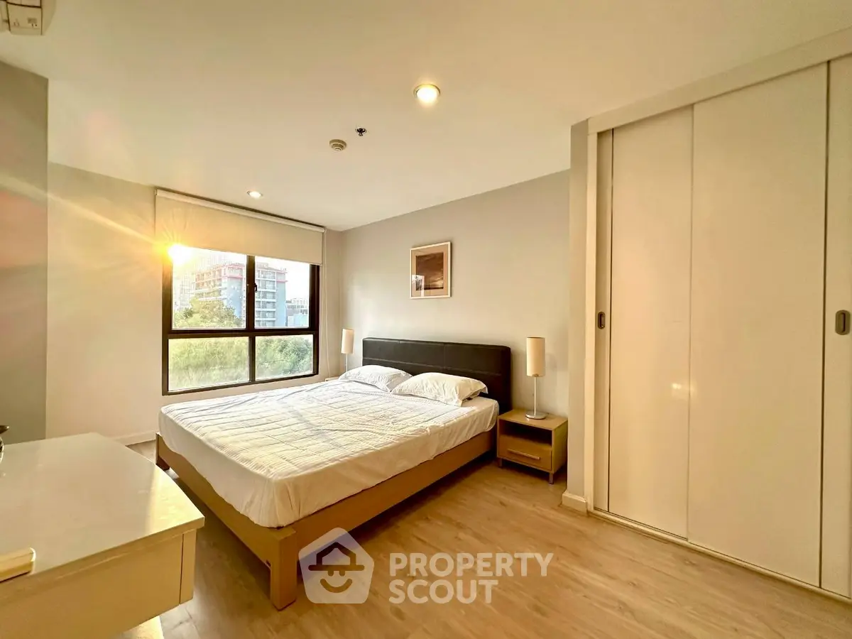 Bright and cozy bedroom with large window and modern furnishings