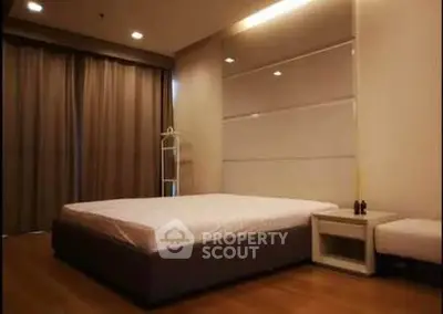 Spacious bedroom with modern design and cozy ambiance, featuring a large bed and elegant decor.