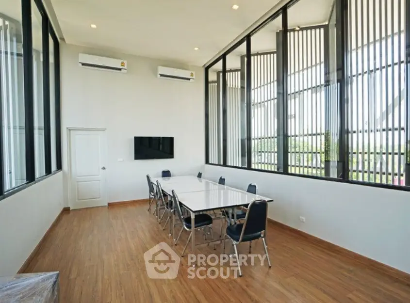 Spacious modern meeting room with large windows and wooden flooring