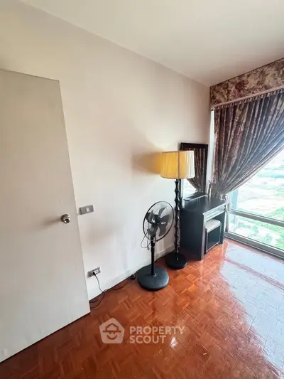 Cozy bedroom corner with elegant lamp and floor-to-ceiling window view