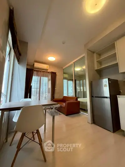 Modern open-plan living room with dining area and kitchen featuring sleek design and natural light.