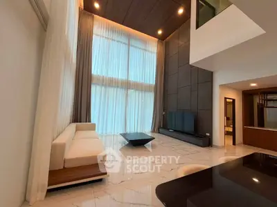 Luxurious high-ceiling living room with modern decor and large windows