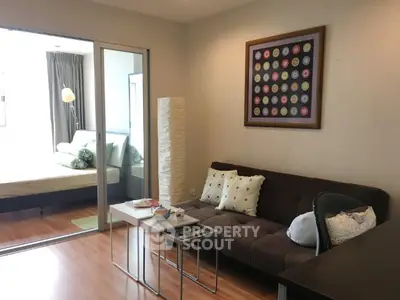 Modern living room with cozy sofa and stylish decor adjacent to a bright bedroom.