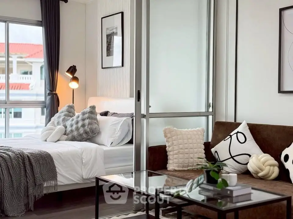 Modern living room with cozy bedroom view, stylish decor, and natural light.