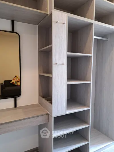 Spacious modern walk-in closet with sleek shelving and mirror, perfect for organized living.
