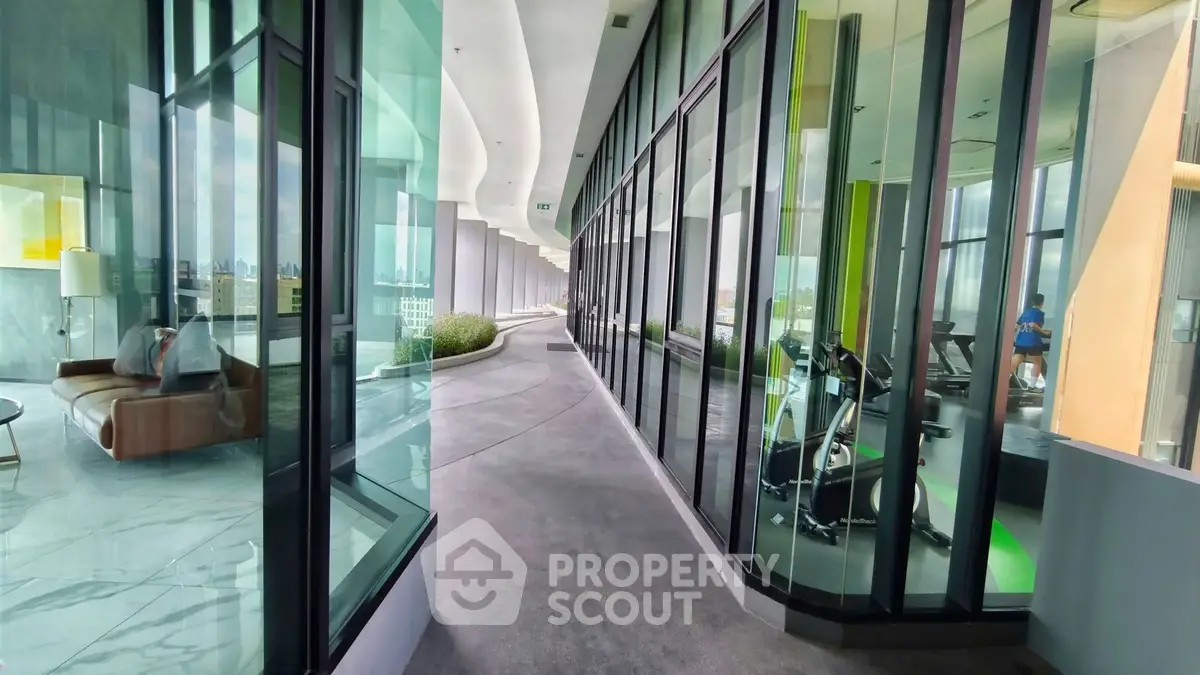 Modern building with glass walls showcasing gym and lounge area