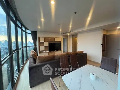Spacious modern living room with panoramic city view and elegant furnishings.