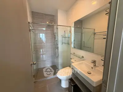Modern bathroom with glass shower and sleek fixtures in a contemporary apartment.