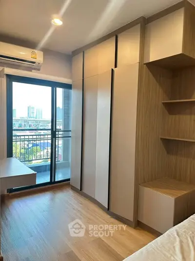Modern bedroom with built-in wardrobe and balcony view in urban apartment