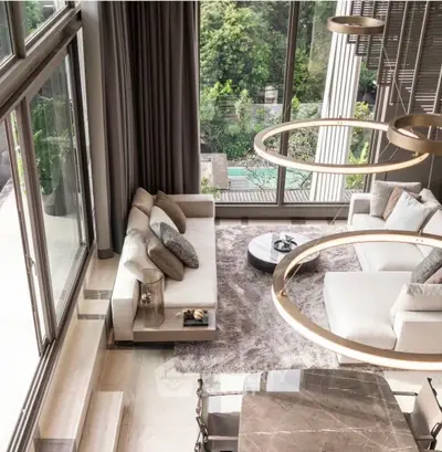 Luxurious living room with floor-to-ceiling windows and elegant decor overlooking a lush garden.