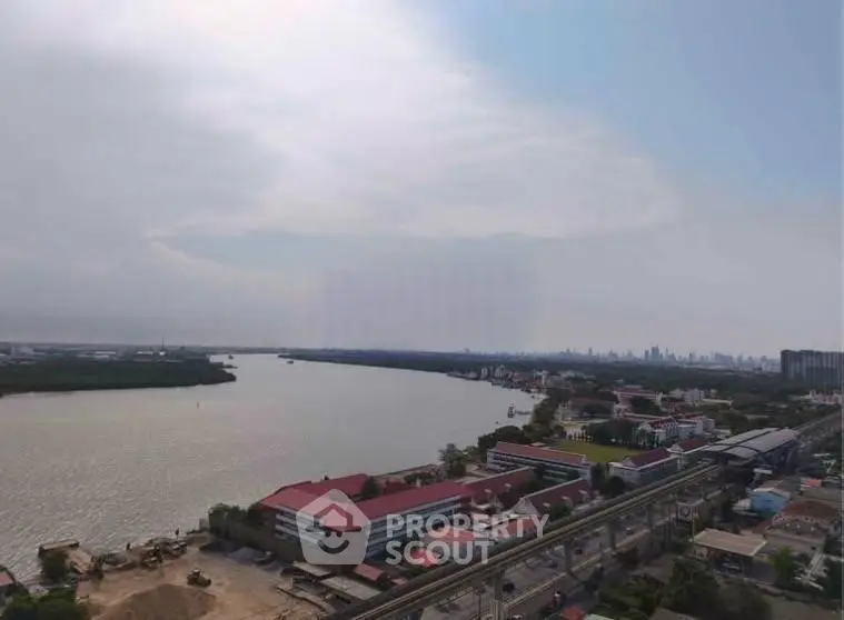 Stunning river view from high-rise building with city skyline in the distance, perfect for urban living.