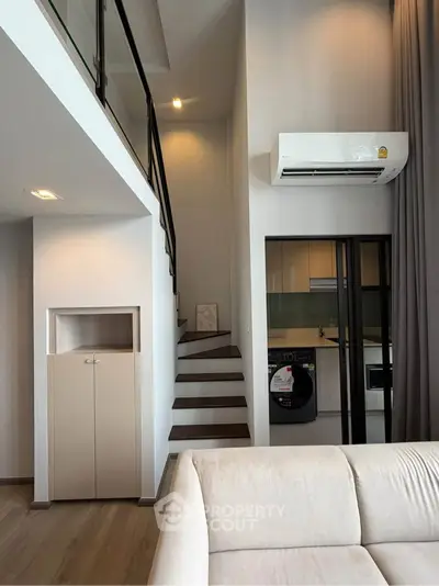 Modern duplex apartment with sleek staircase and open kitchen layout
