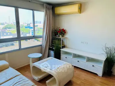 Bright living room with large window and modern furniture in urban apartment