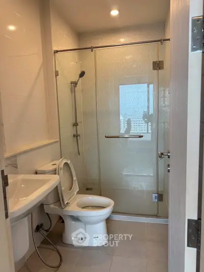 Modern bathroom with glass shower and sleek fixtures in a contemporary apartment.