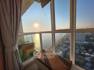Stunning high-rise balcony view overlooking the ocean at sunset, perfect for relaxation and enjoying the scenery.
