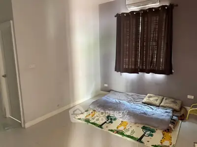Minimalist bedroom with floor mattress and air conditioning, perfect for cozy living.