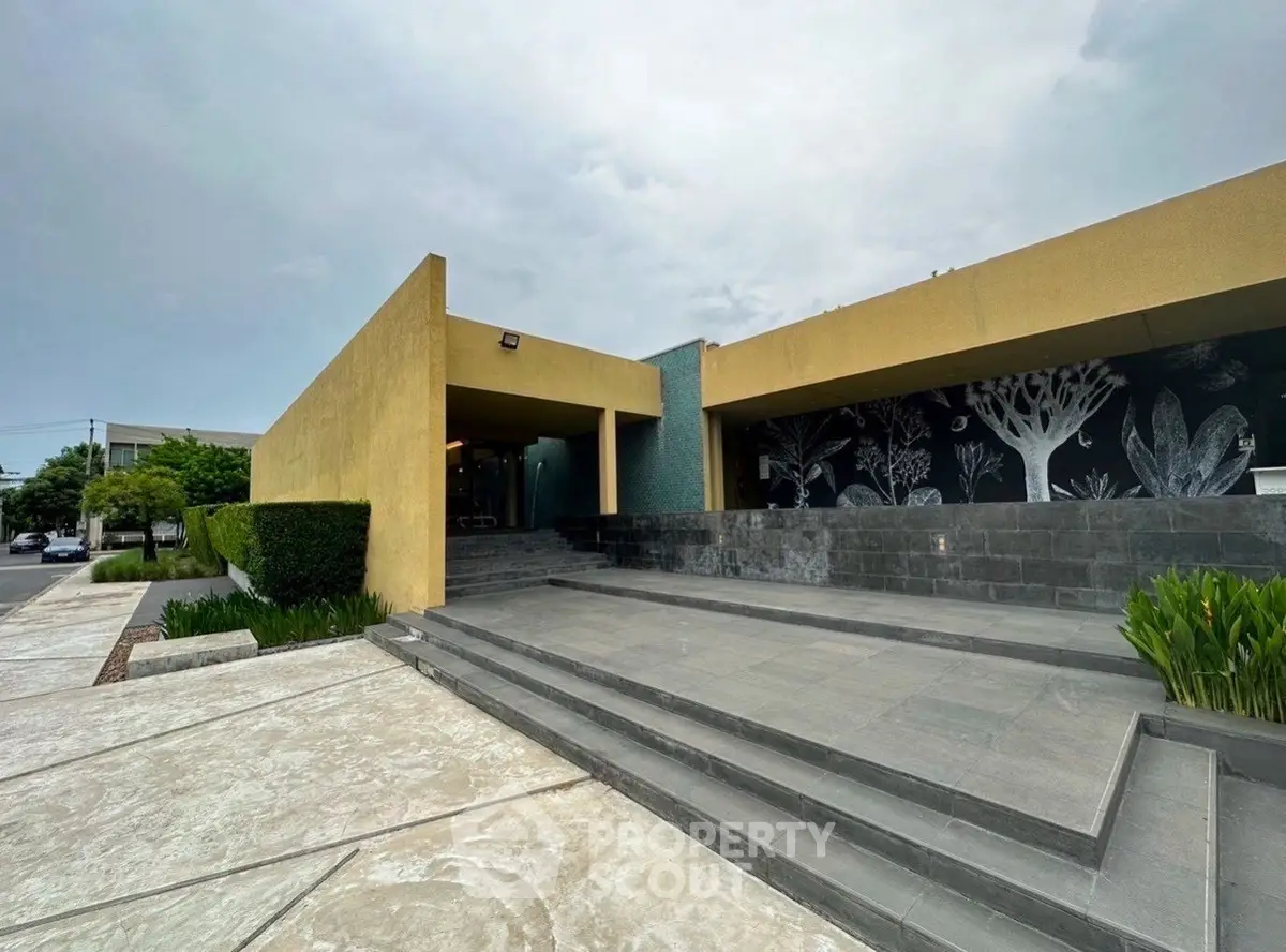 Modern building entrance with sleek design and artistic wall mural