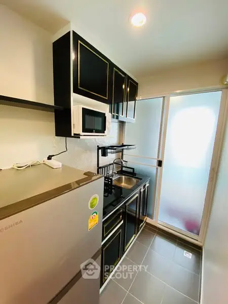 Modern kitchen with sleek black cabinets and stainless steel appliances