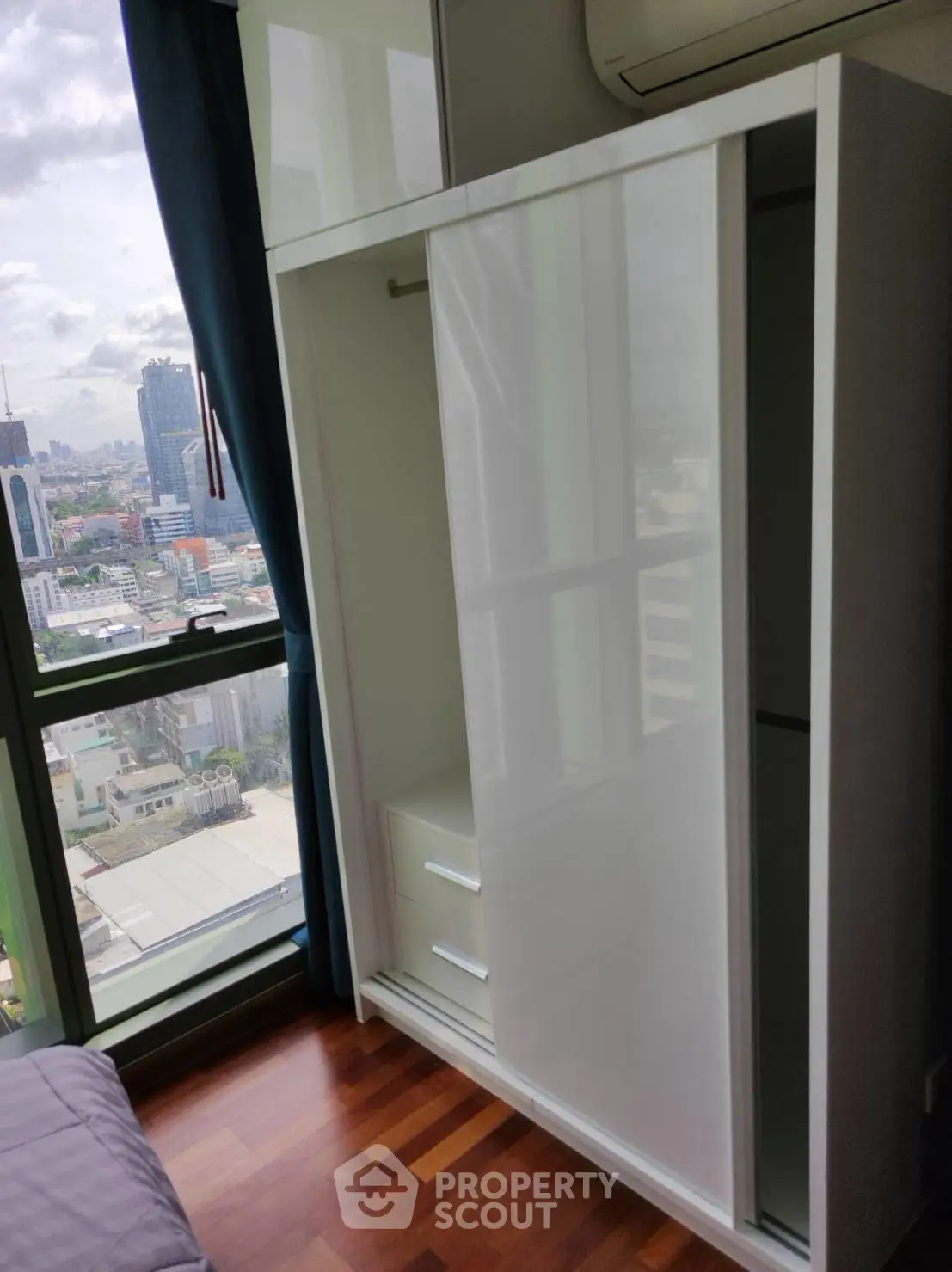 Modern bedroom with sleek wardrobe and city view from large window