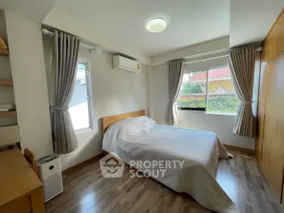 Cozy bedroom with natural light and wooden accents, perfect for relaxation.
