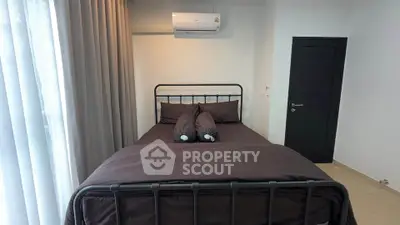 Modern bedroom with sleek black bed frame and air conditioning